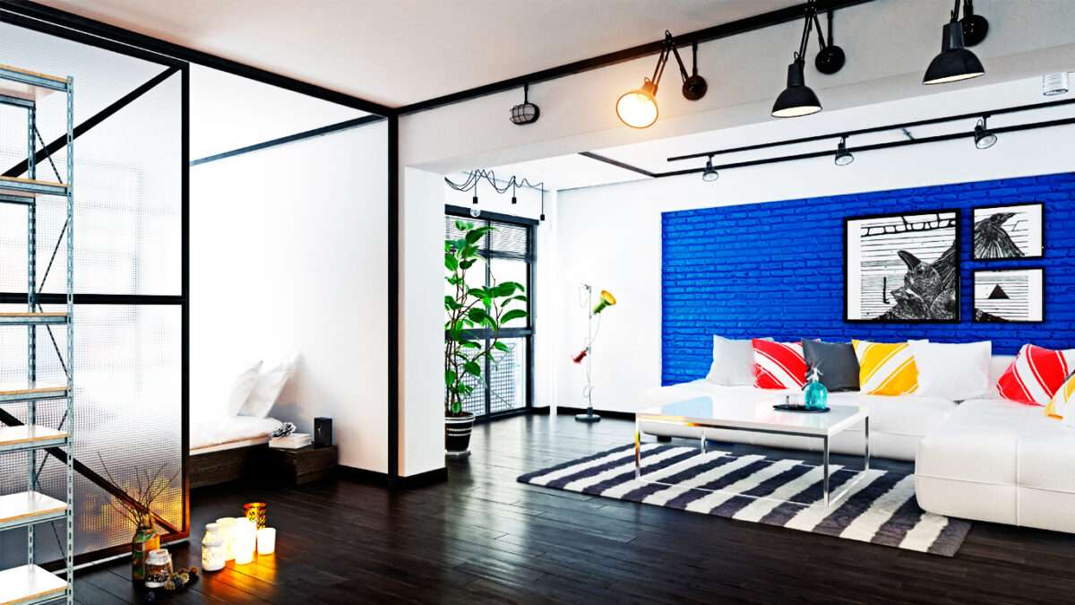 Banner mostrando uma sala de estar integra ao quarto com uma divisória de vidro aramado do lado esquerdo servindo como separador dos dois ambientes.